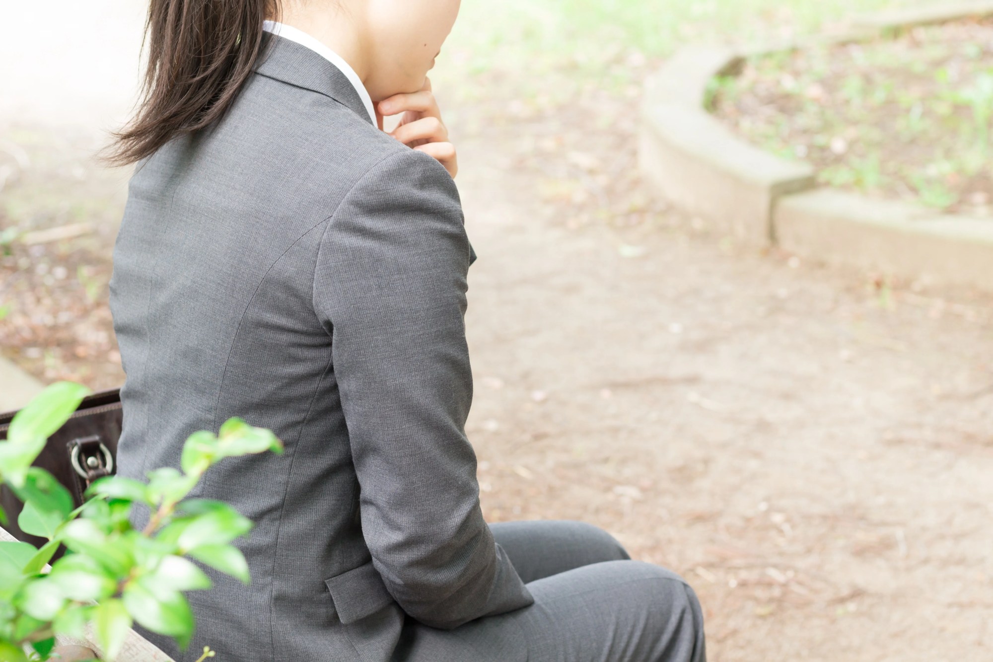 「適応障害」のイメージ_講演のベンチに座り込む女性の後ろ姿