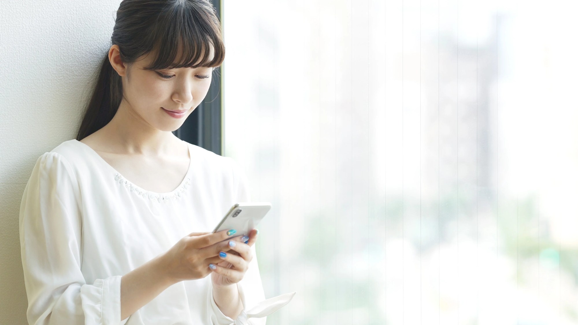 「HELPO」のイメージ_笑顔でスマホを見ている女性