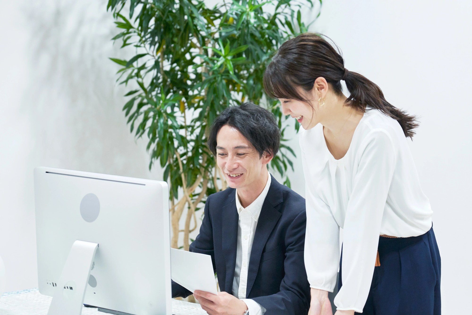「円滑なコミュニケーション」のイメージ_笑顔で仕事の会話をしている男女