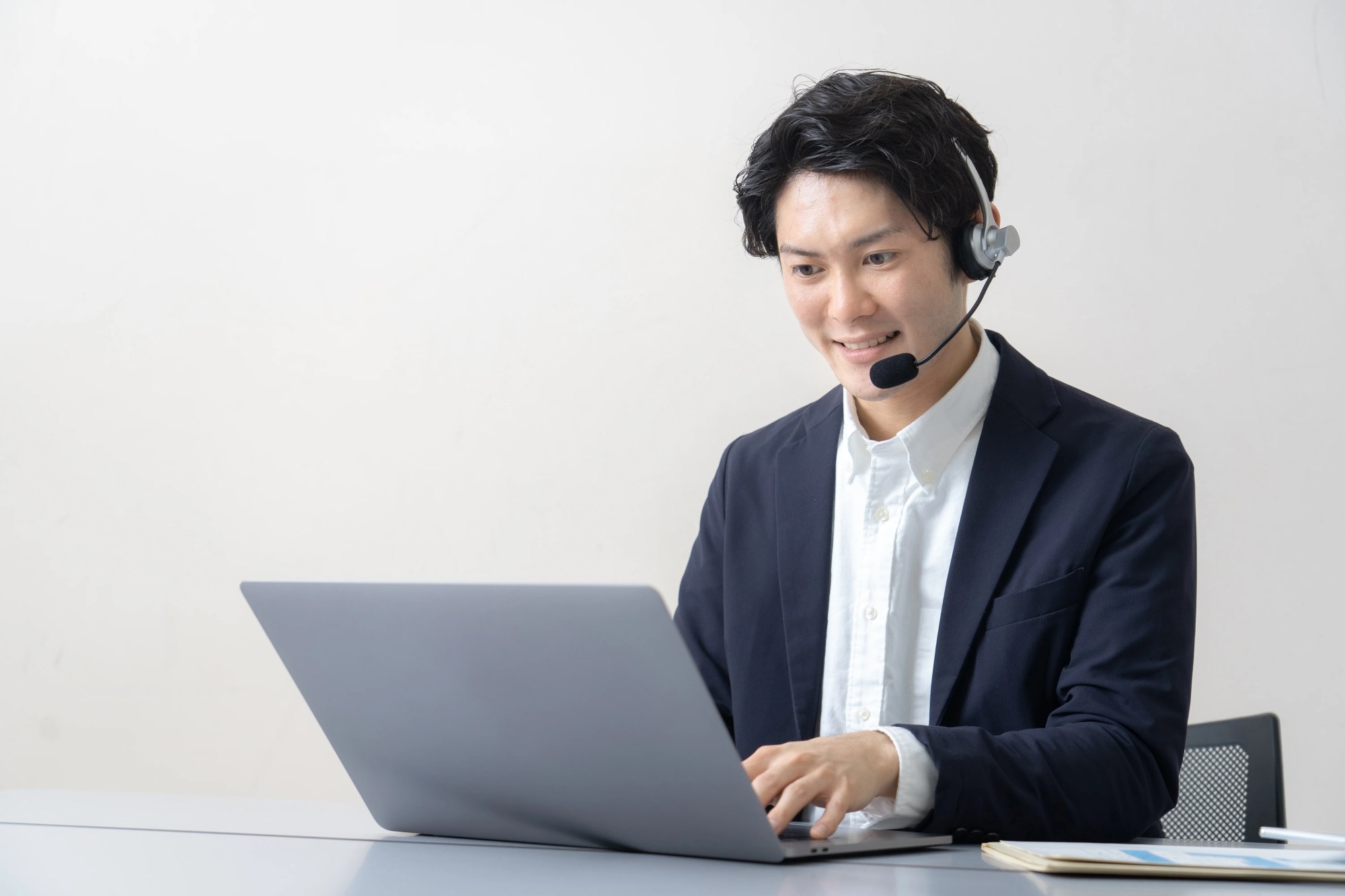 「オペレーター」のイメージ_ヘッドマイクをつけ、笑顔で対応している男性