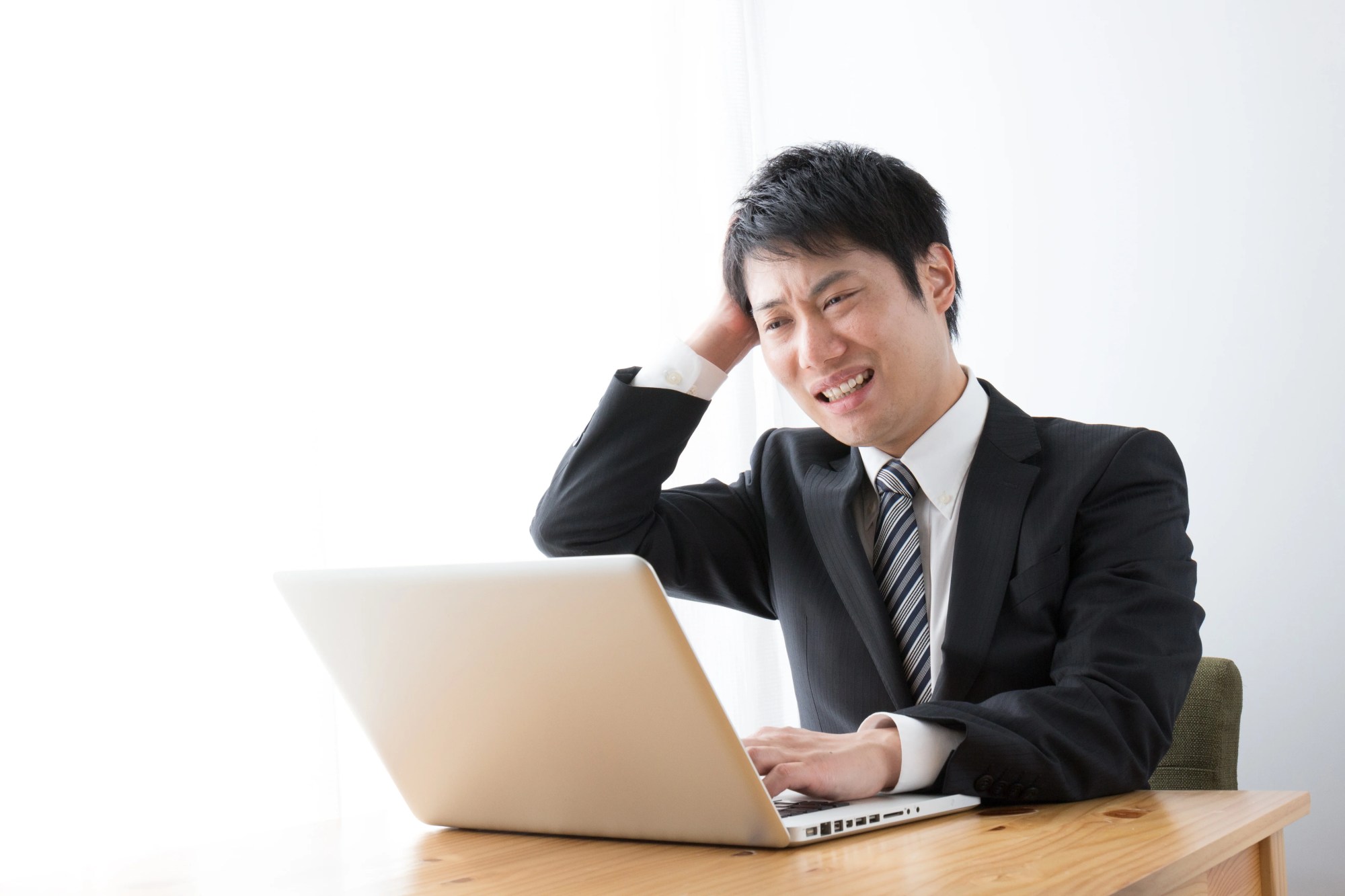 「ストレス」のイメージ_パソコンを見てイライラした様子の男性