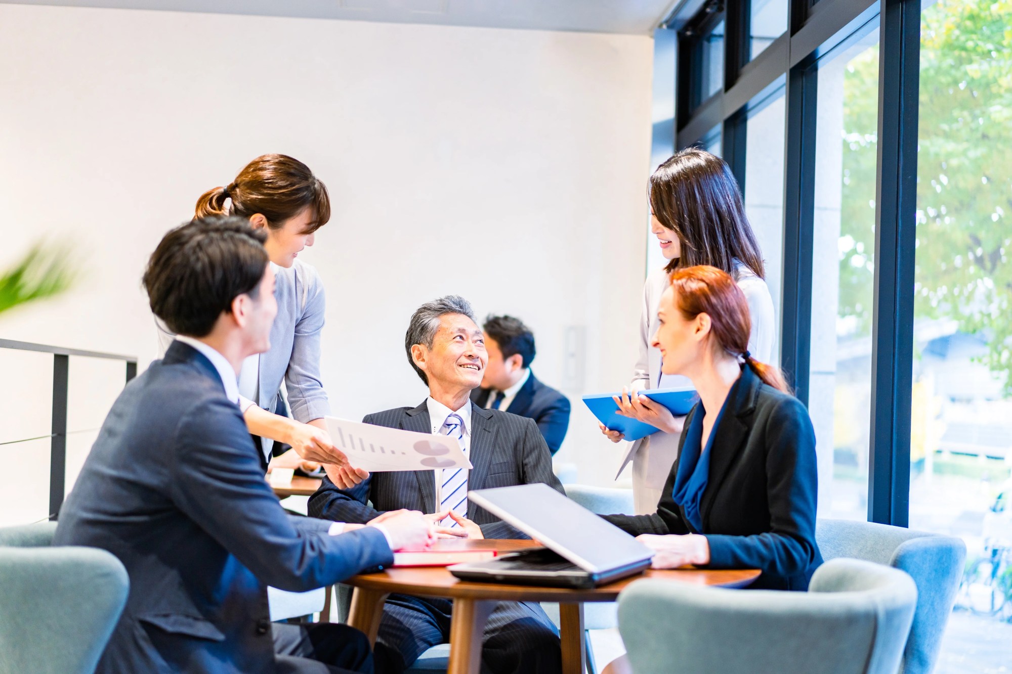 「良好な職場環境」のイメージ_上司と複数名の部下が笑顔で話をしている様子