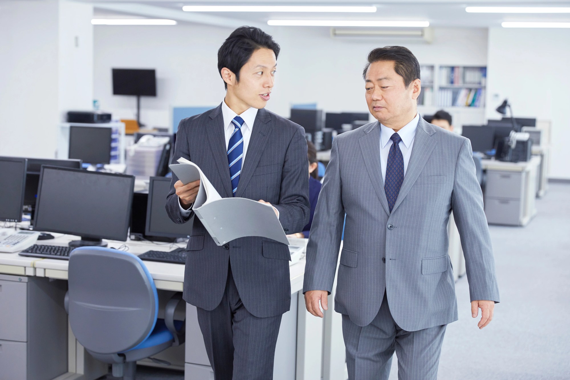 「相談」のイメージ_歩きながら上司に相談する男性社員