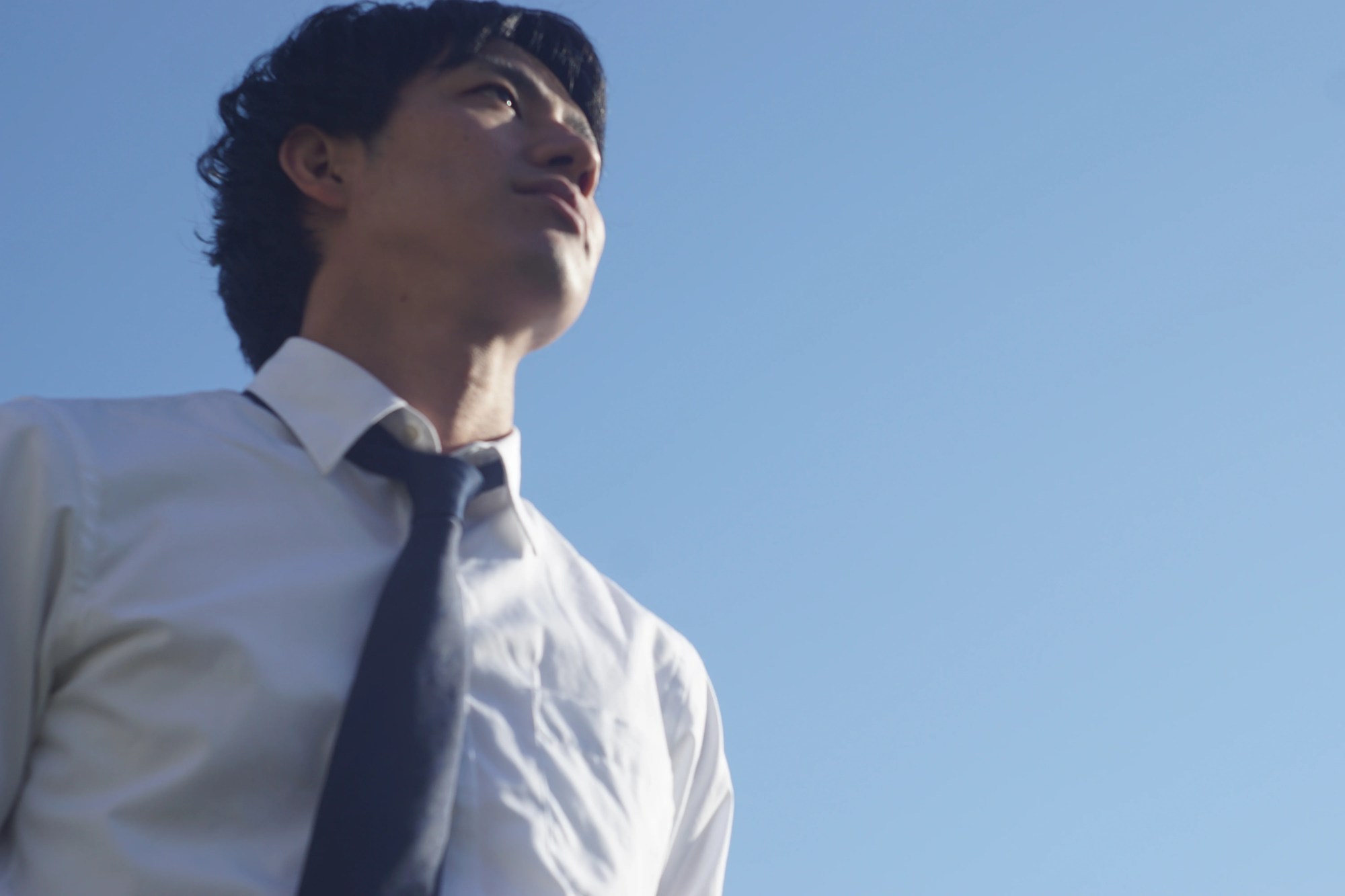 「ソリューション」のイメージ_真剣な表情で空を見上げる男性