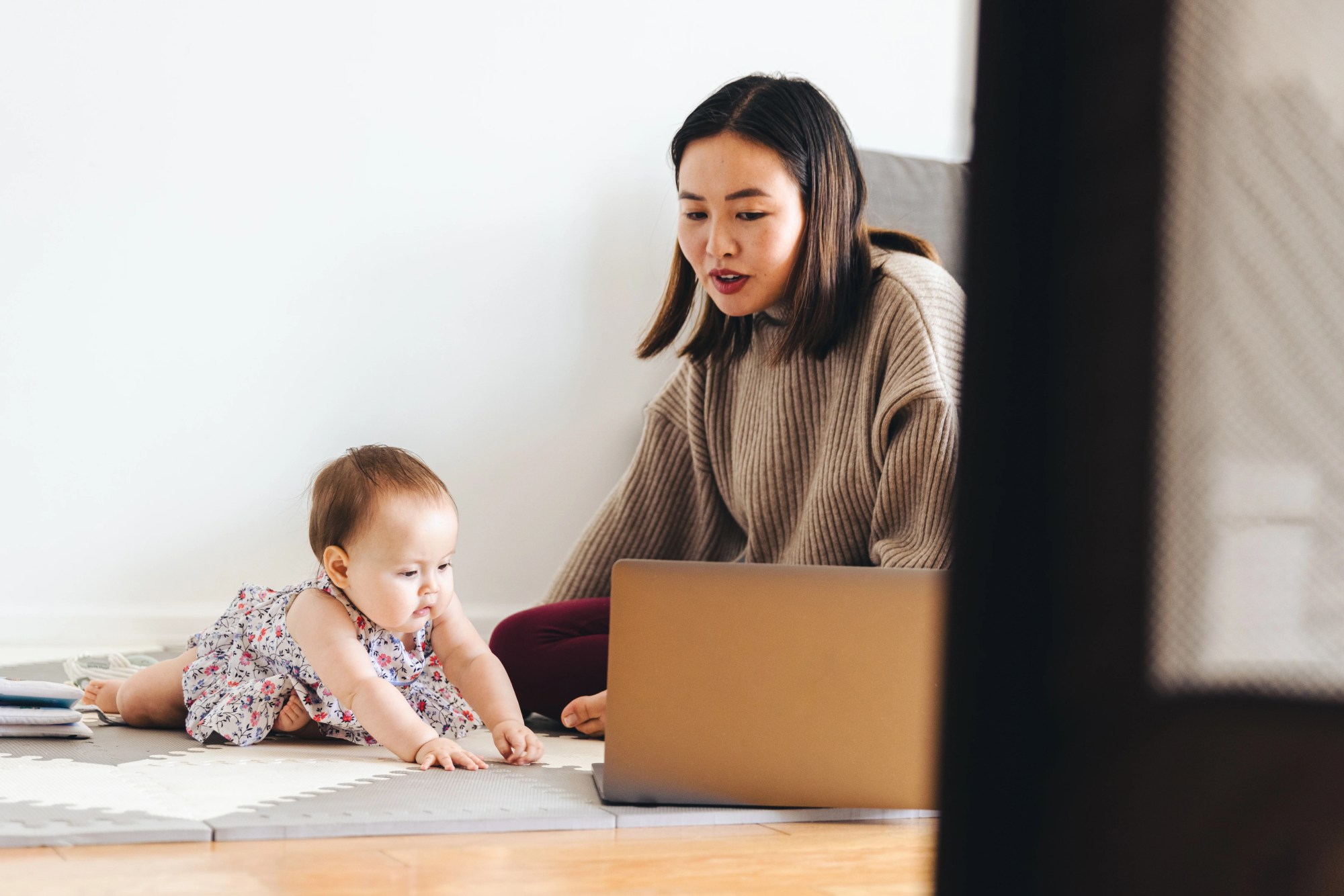 「リモートワーク」のイメージ_赤ちゃんとあやしながら仕事をしている様子