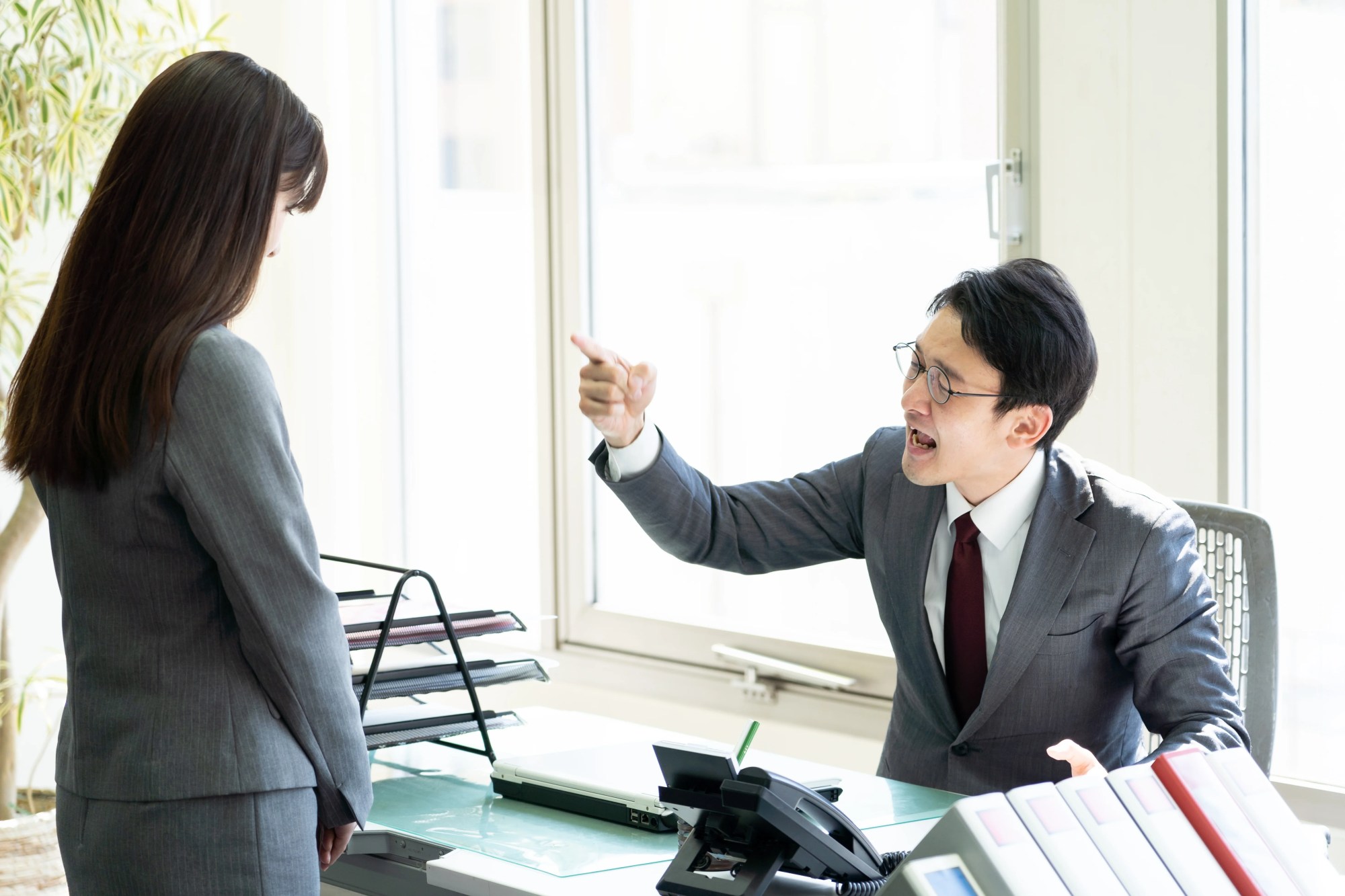 「ストレス」のイメージ_叱責する男性管理職と、話を聞く部下