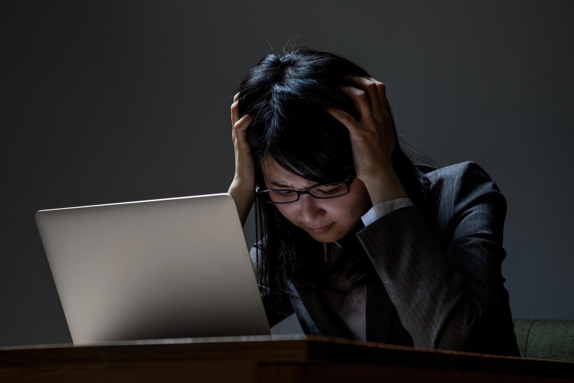 「精神疾患」のイメージ_パソコンの前で頭を抱える女性