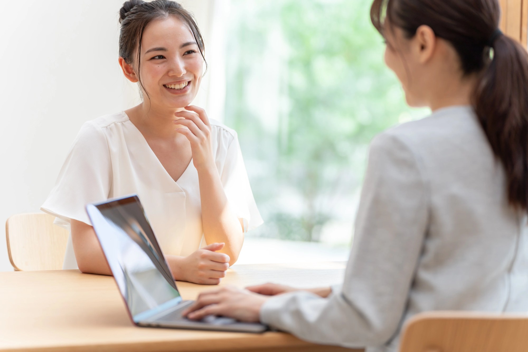 「会議」のイメージ_笑顔で話をする女性と、話を聞く管理職の女性