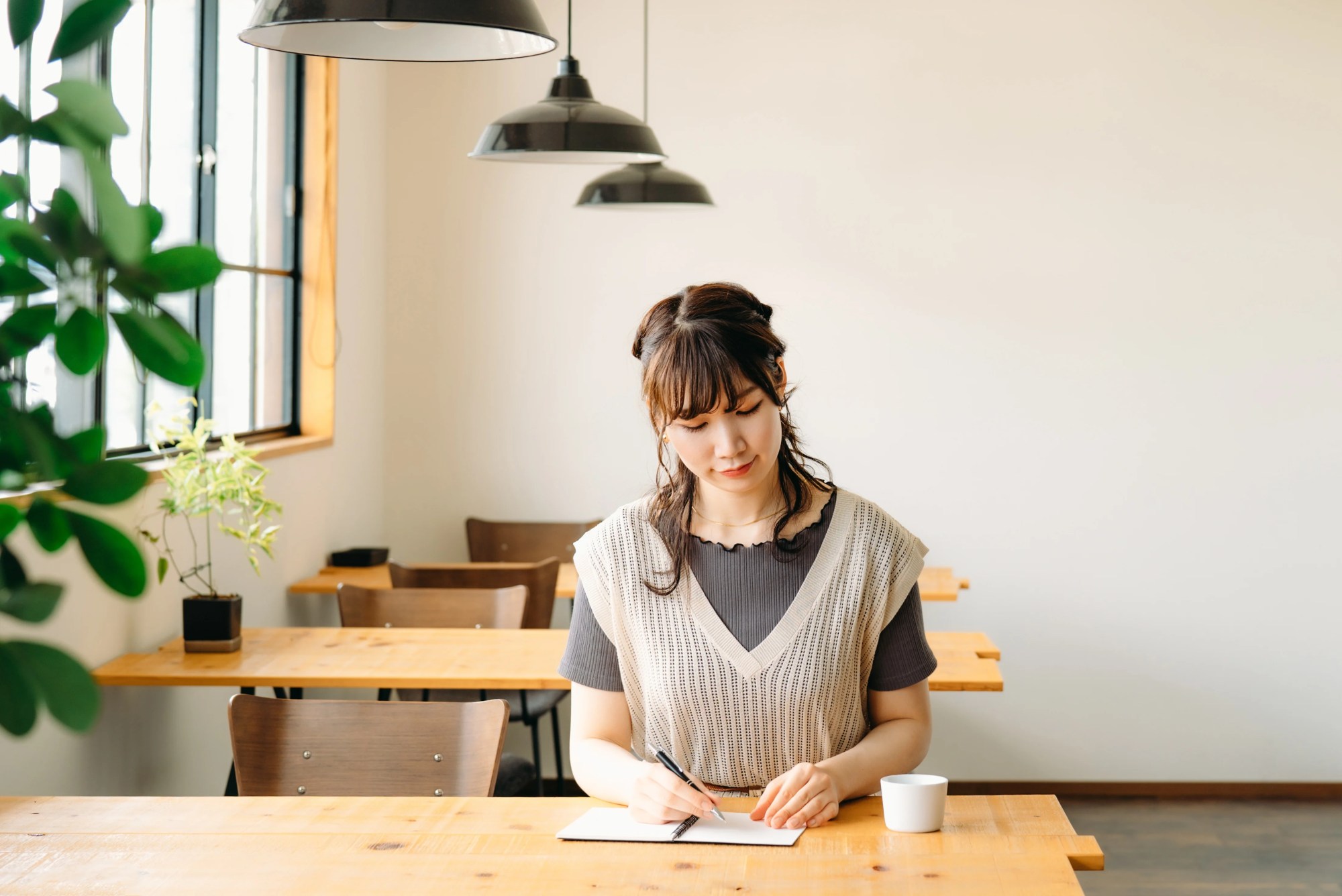 「勉強」のイメージ_微笑みながらノートにメモを取っている女性