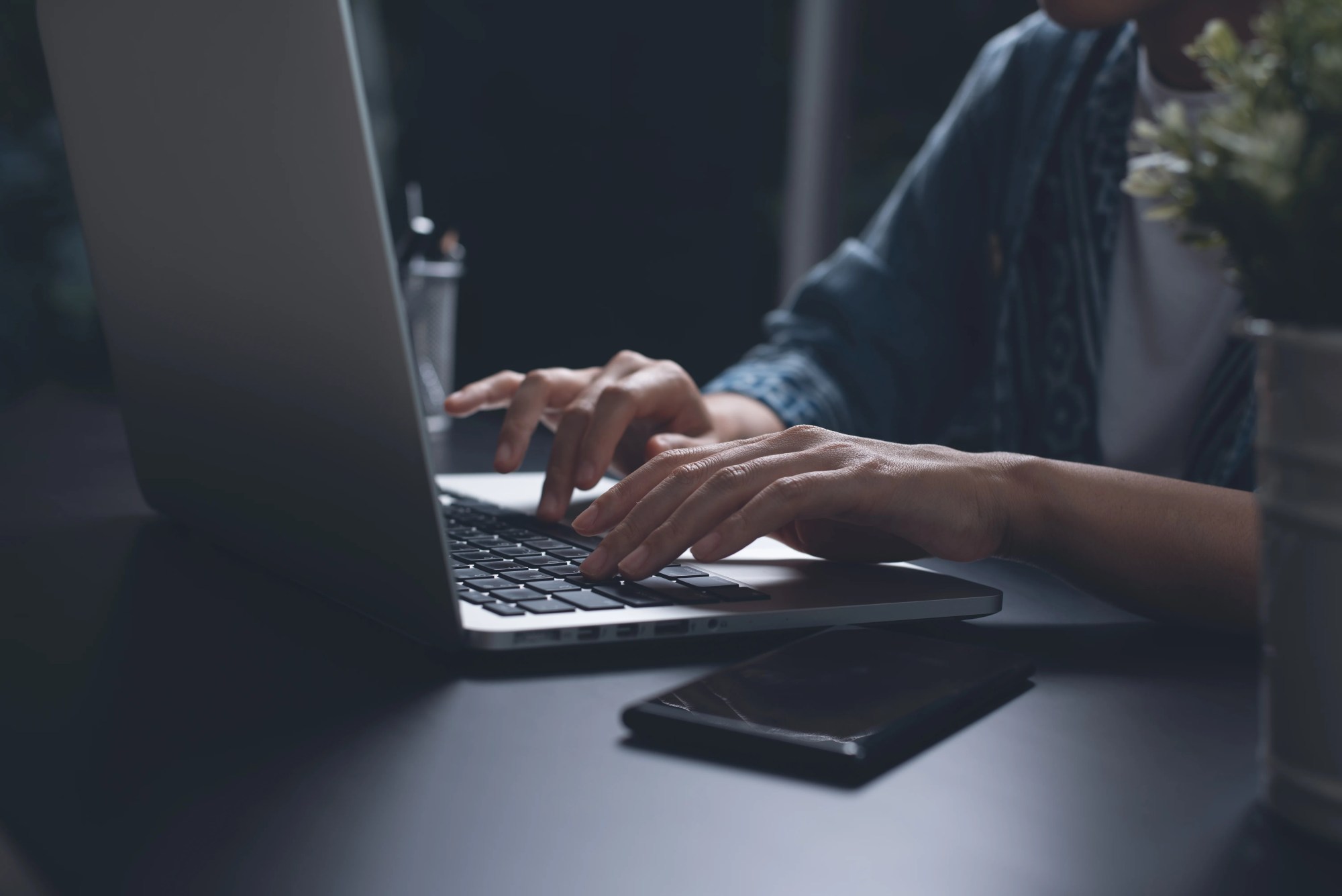 「仕事」のイメージ_暗い部屋でパソコンを操作する男性の手元