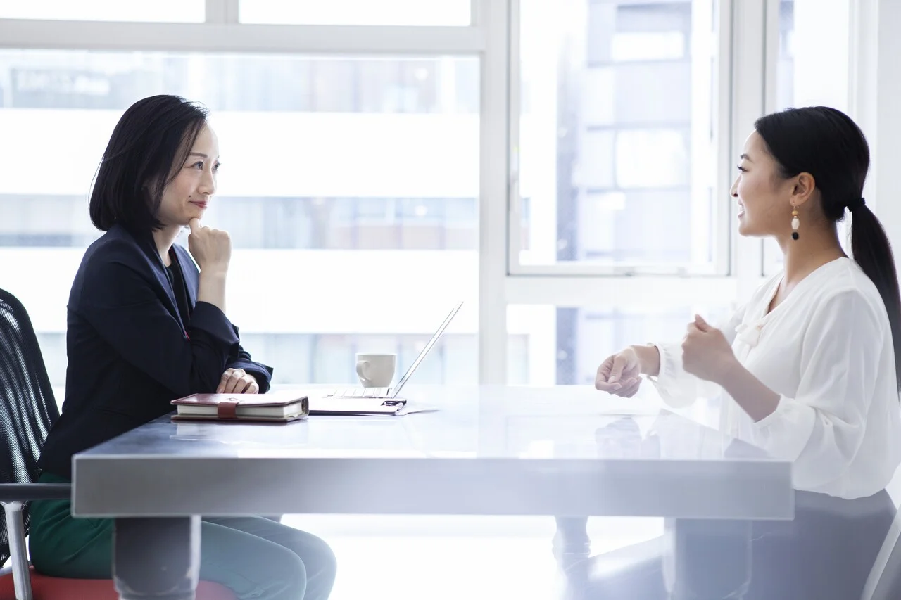 「1on1」のイメージ_笑顔で話をしている女性管理職と女性社員