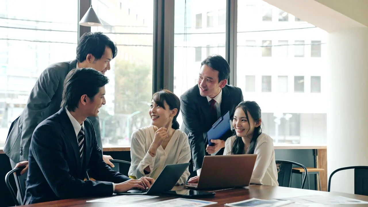 「健康経営」のイメージ_笑顔で話をしている5名の社員