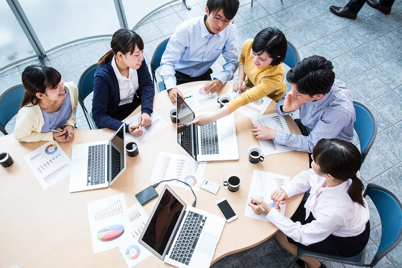 「意見交換」のイメージ_真剣に意見を交換している複数名の社員を俯瞰的に見ている様子