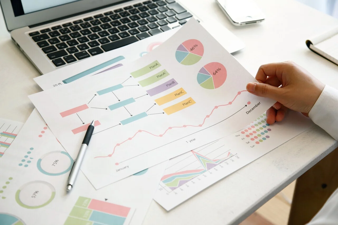 「データ」のイメージ_複数のグラフを眺める男性の手元