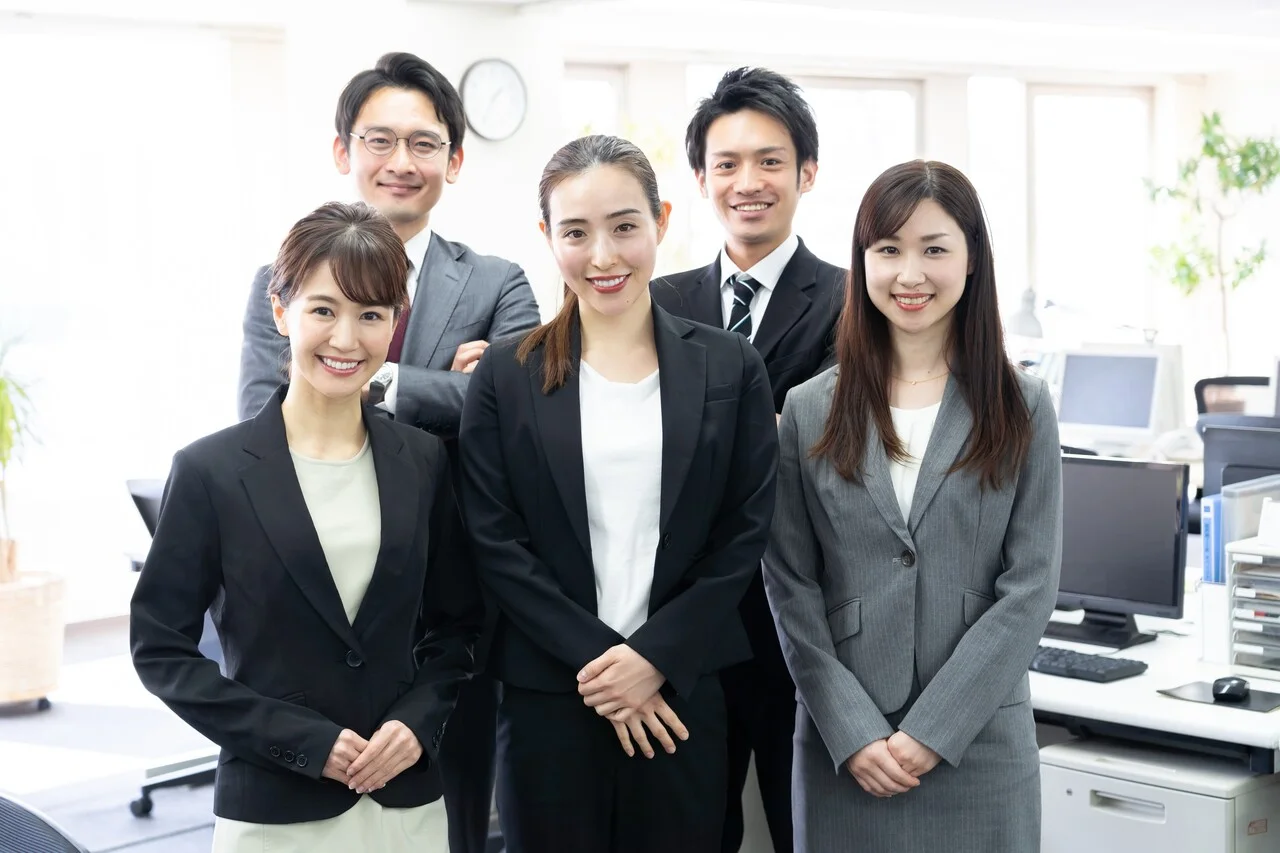 「課題解決」のイメージ_笑顔でこちらを見ている5名の社員