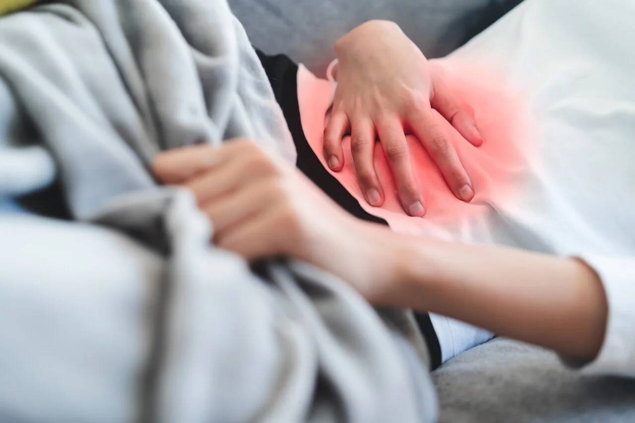 「感染性胃腸炎」のイメージ_腹部を押さえる女性の手元