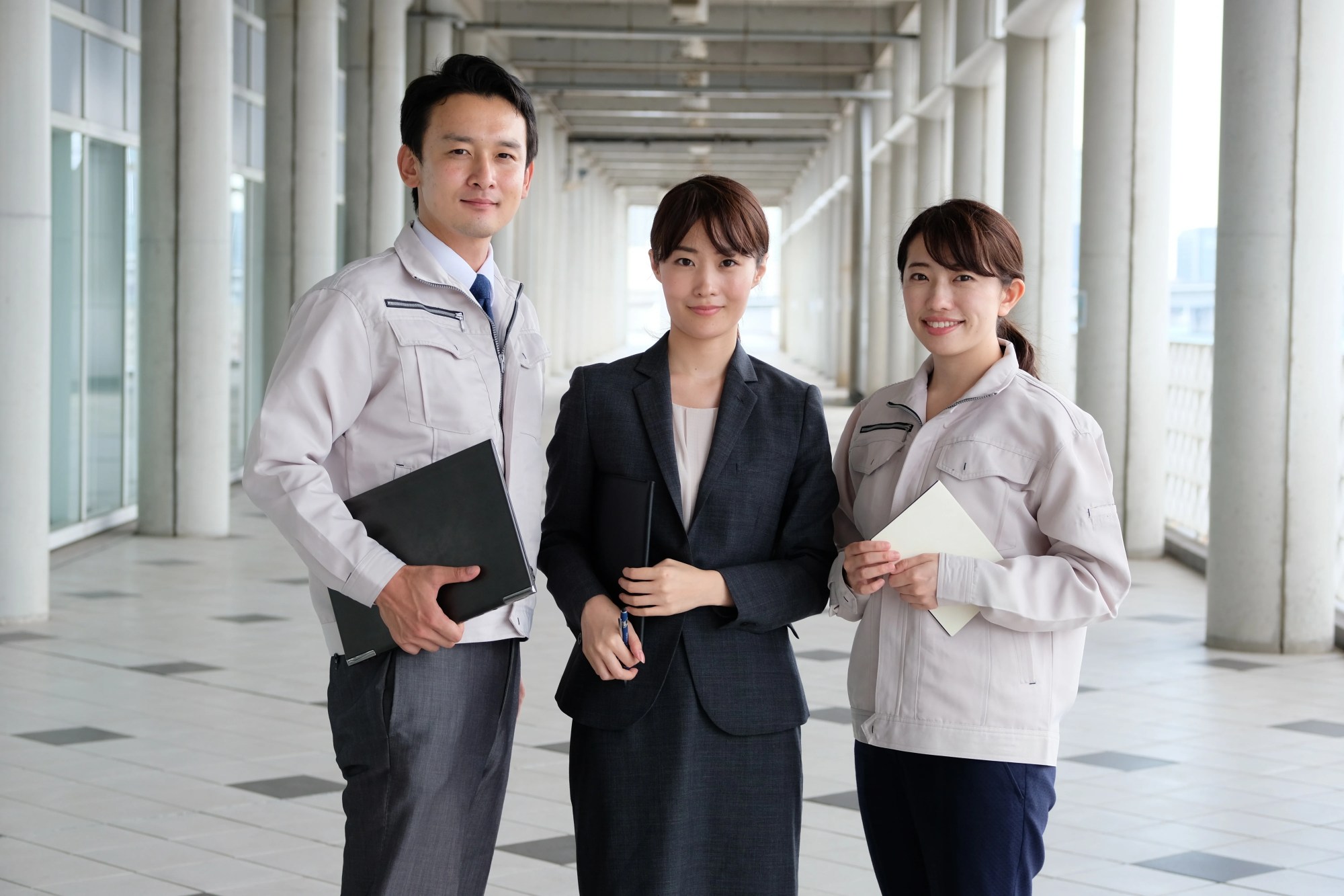 「解決策」のイメージ_笑顔でこちらを向く3名の社員