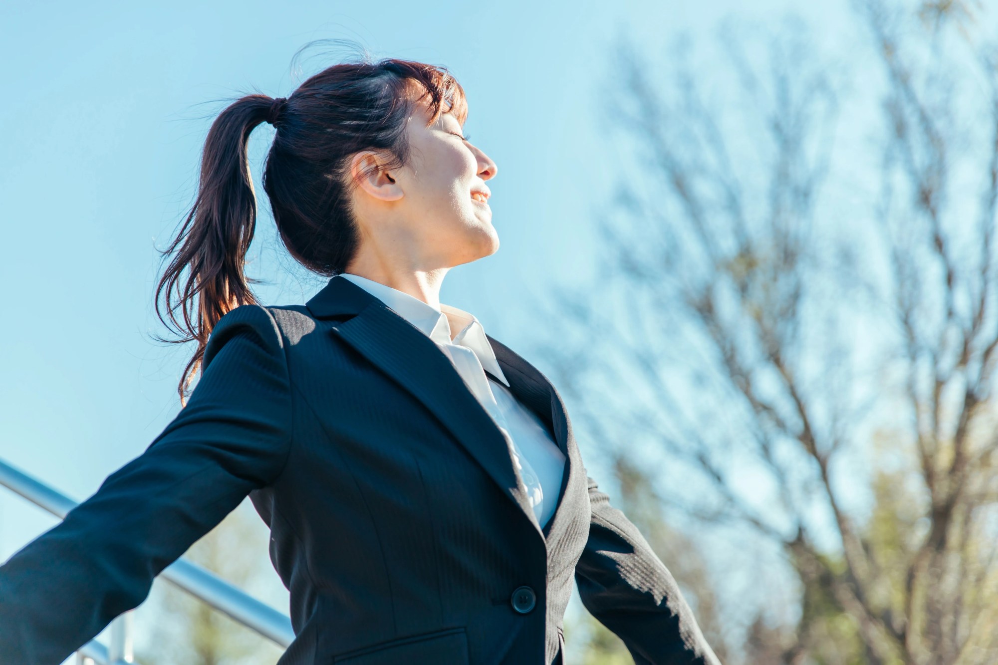 「ストレスフリー」のイメージ_清々しい笑顔で両手を広げる女性