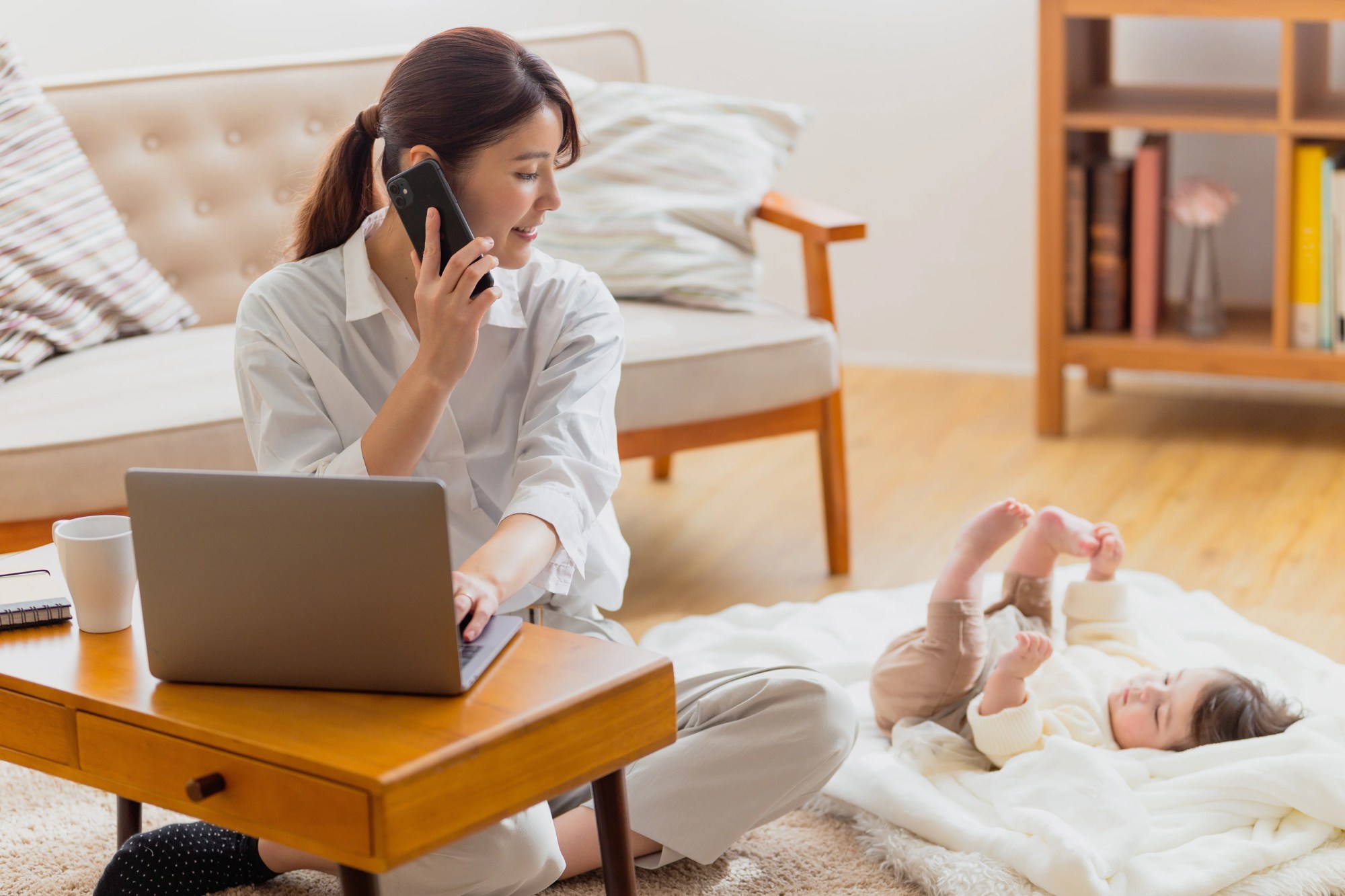 「リモートワーク」のイメージ_女性が赤ちゃんをあやしながら仕事をしている様子
