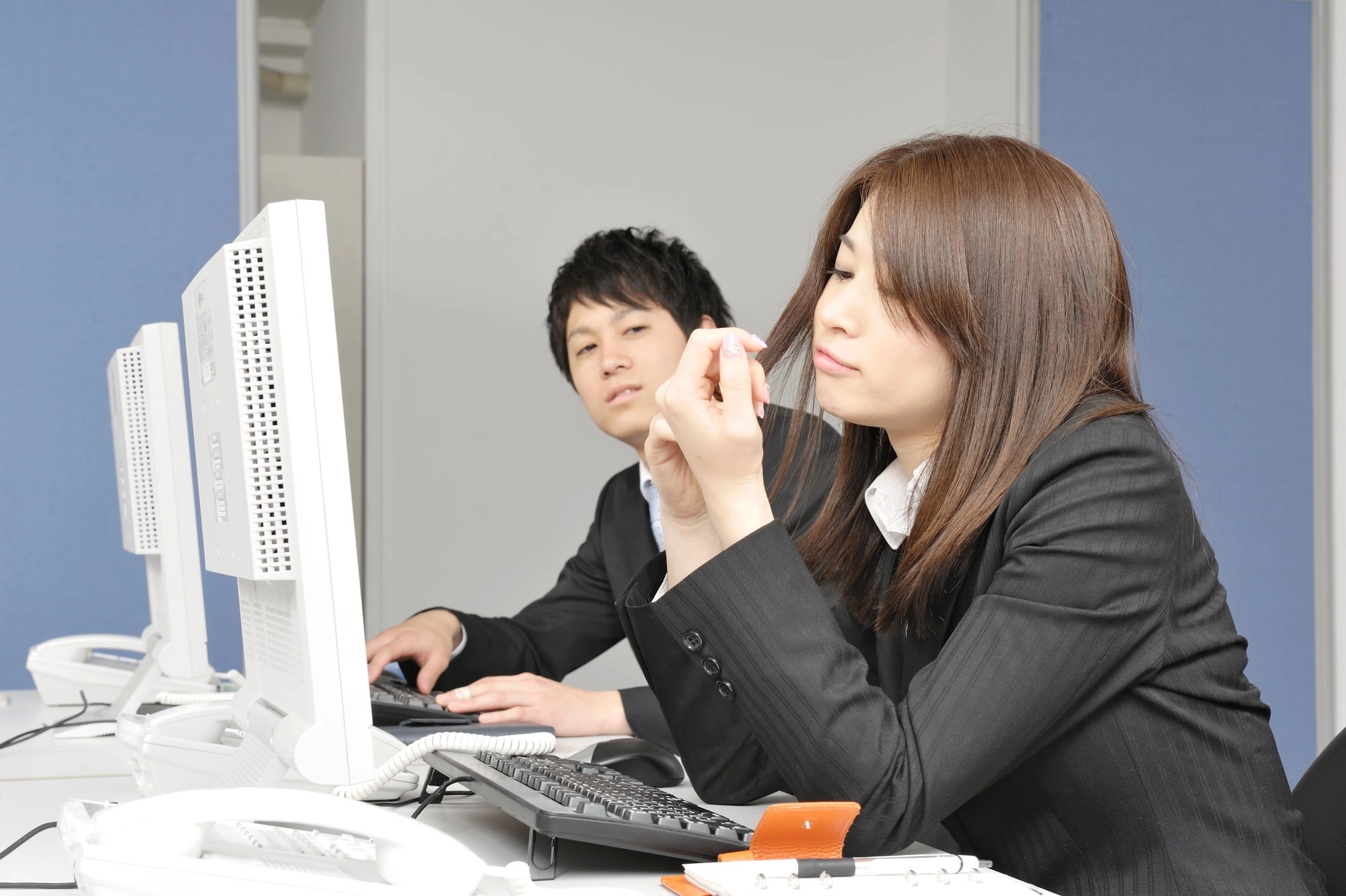 「モンスター社員」イメージ_やる気がなさそうに爪をいじる女性社員