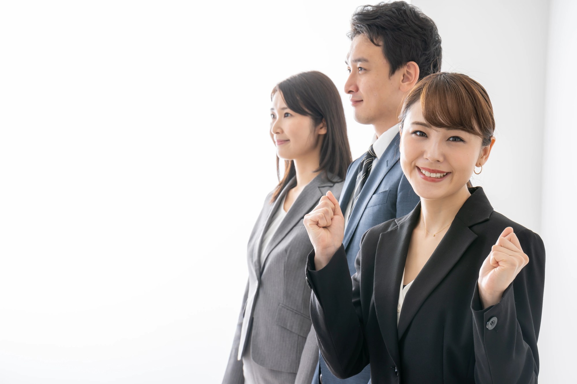 「解決策」のイメージ_笑顔で前を向く男女社員と、こちらを見てガッツポーズをする女性社員