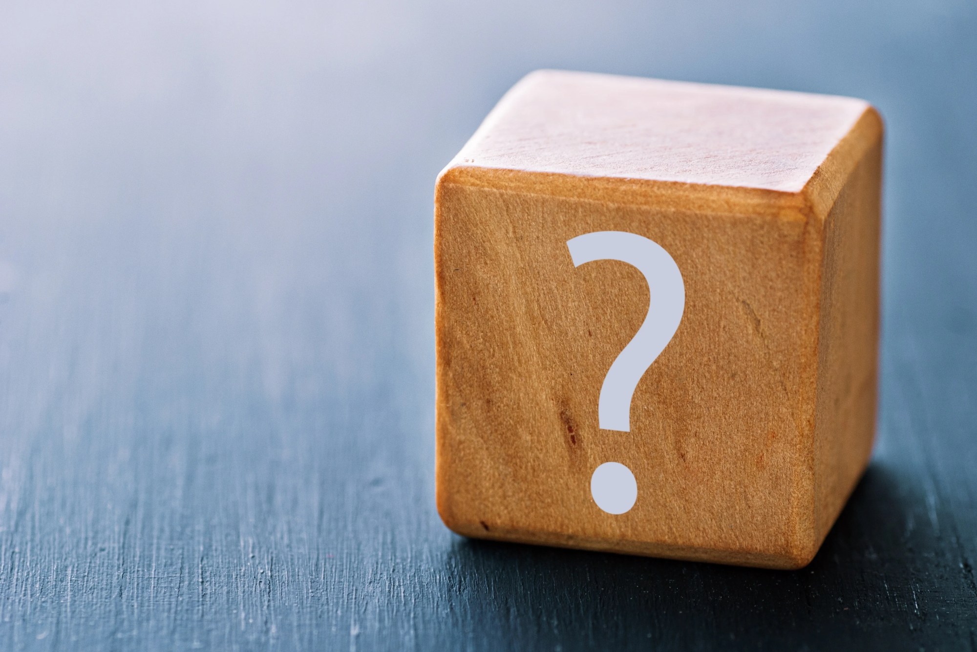 「問い」のイメージ_クエスチョンマークがプリントされた木製ブロック