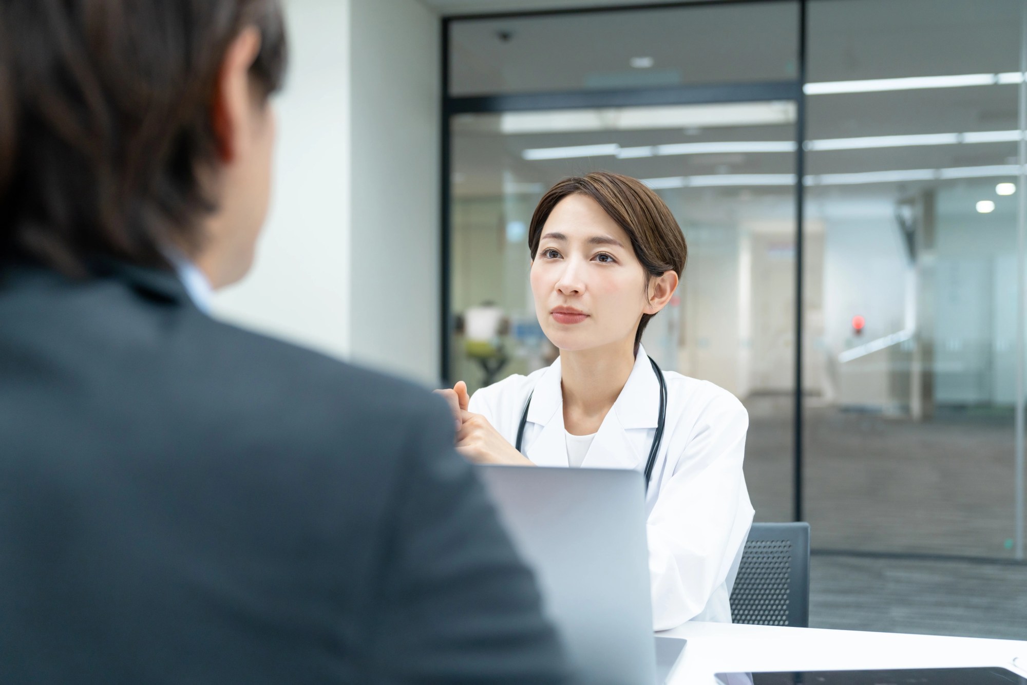 「産業医」のイメージ_真剣な表情で男性の話を聞く産業医