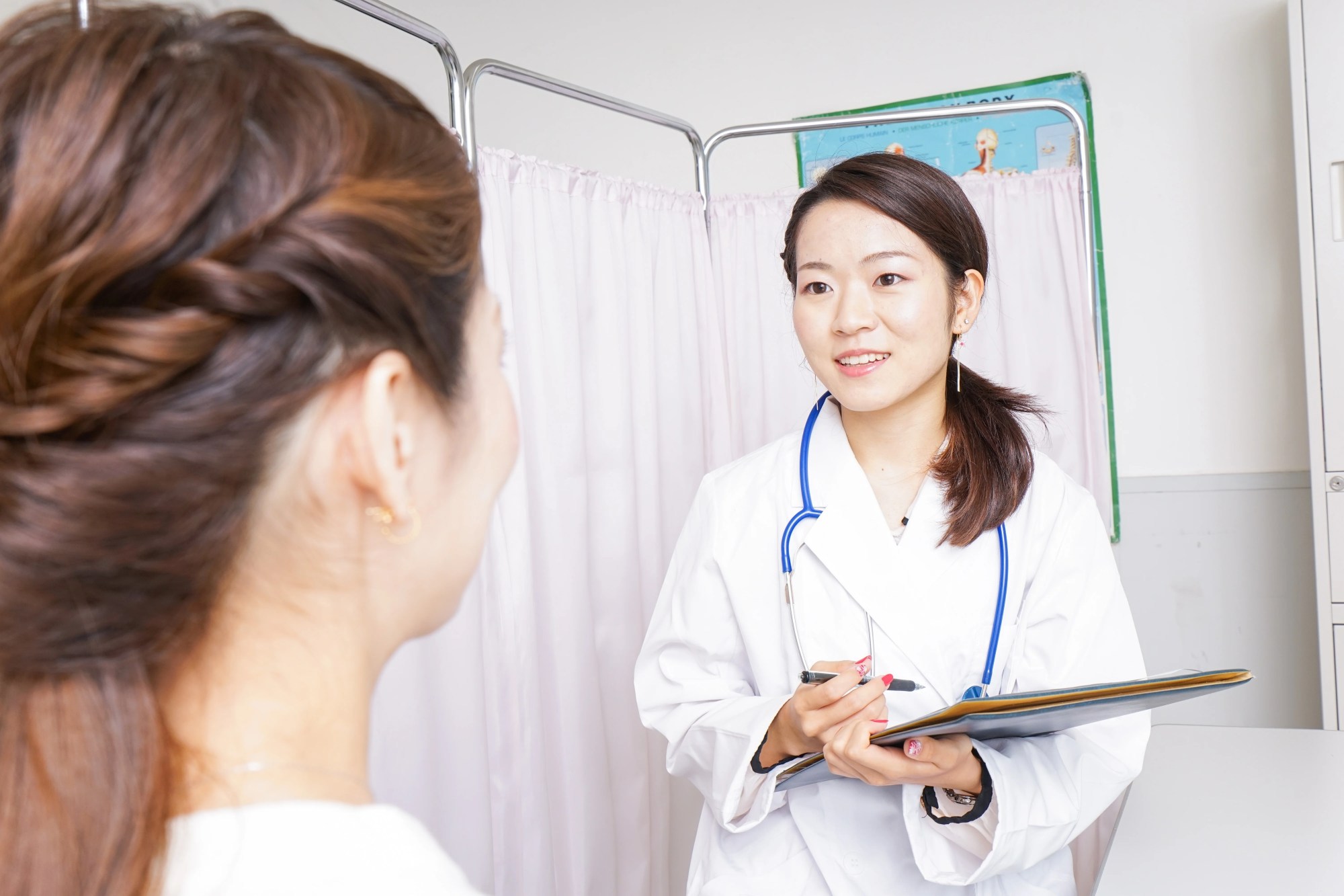 「診療」のイメージ_笑顔で話を聞く医師