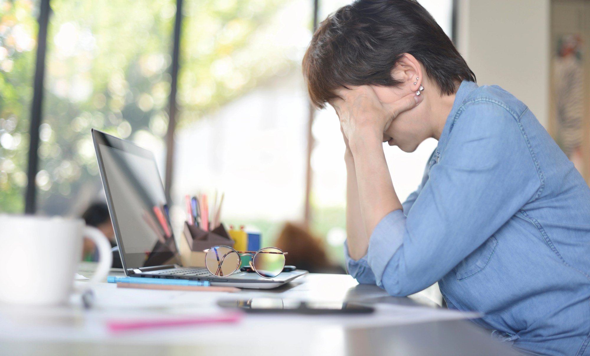 「ストレス」のイメージ_デスクで頭を抱える女性