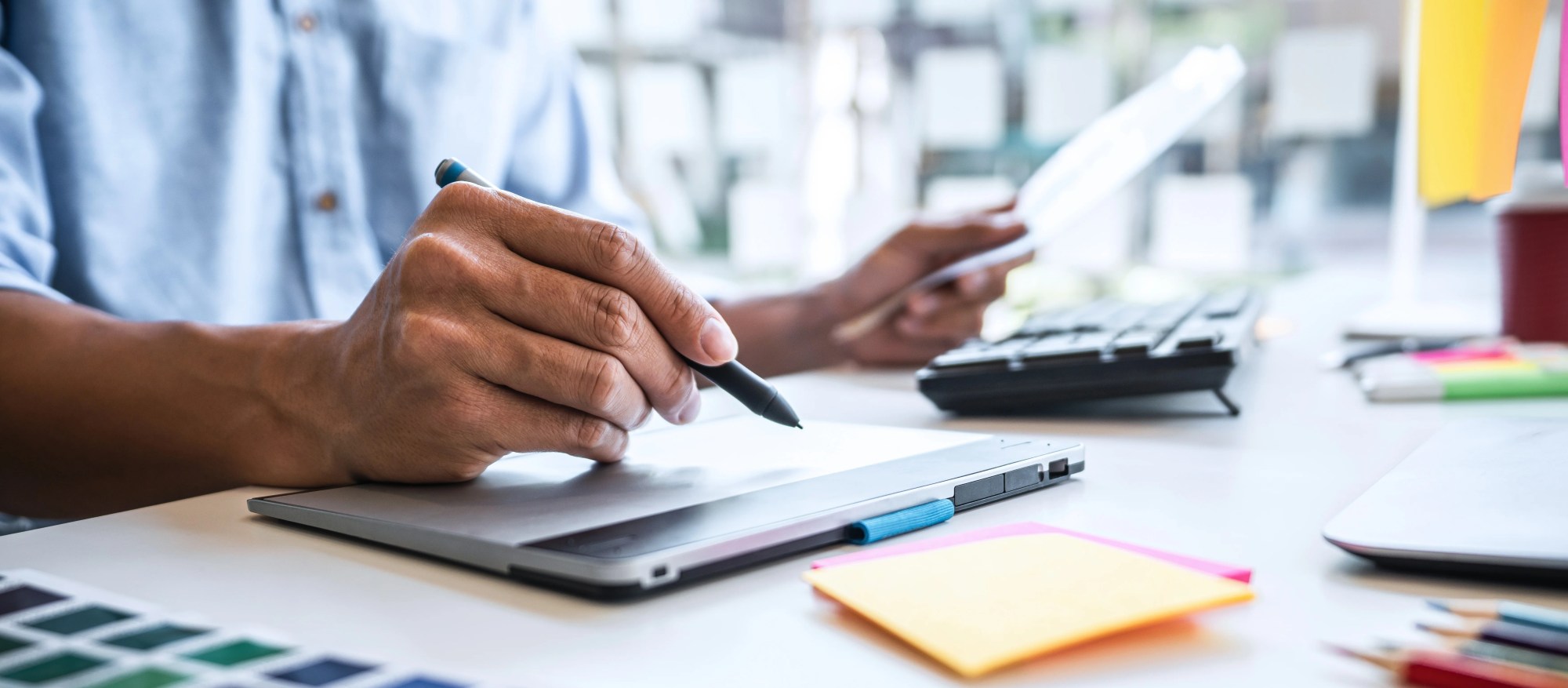 「導入」のイメージ_複数の書類を見ながら考える男性の手元