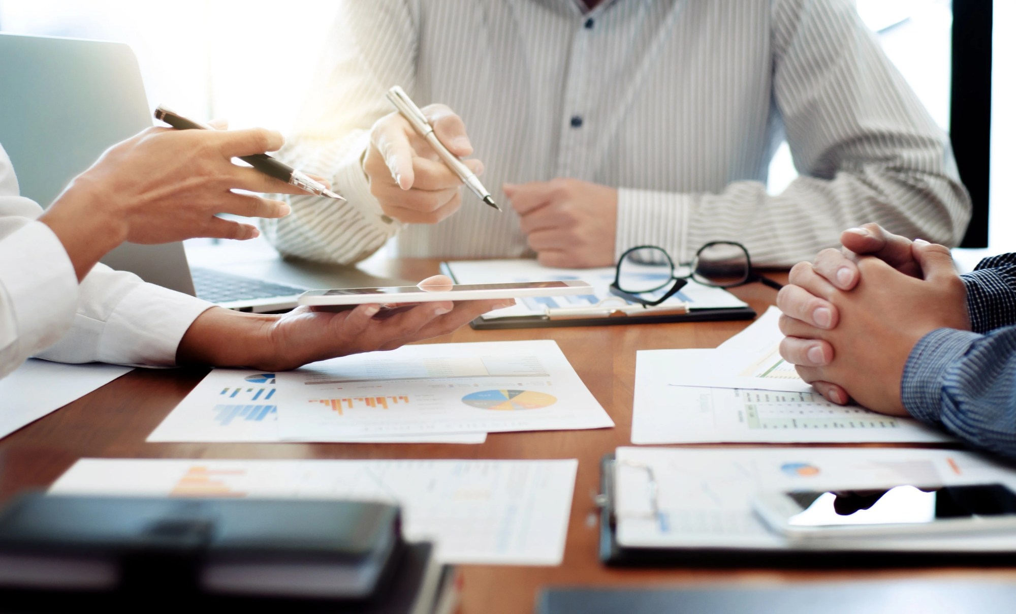 「導入」のイメージ_データを元に真剣に話し合いを行う複数名の手元