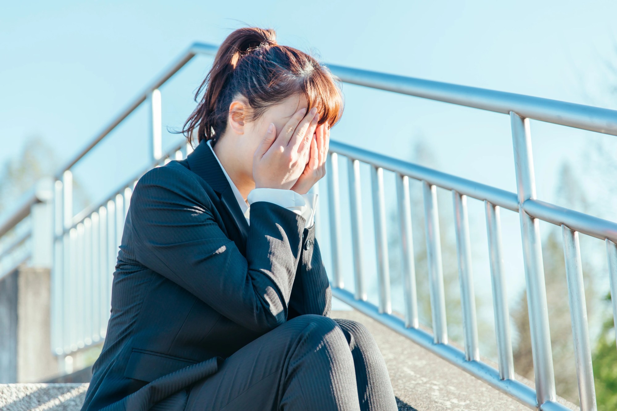 「ストレス」のイメージ_階段で座り込み、落ち込む女性