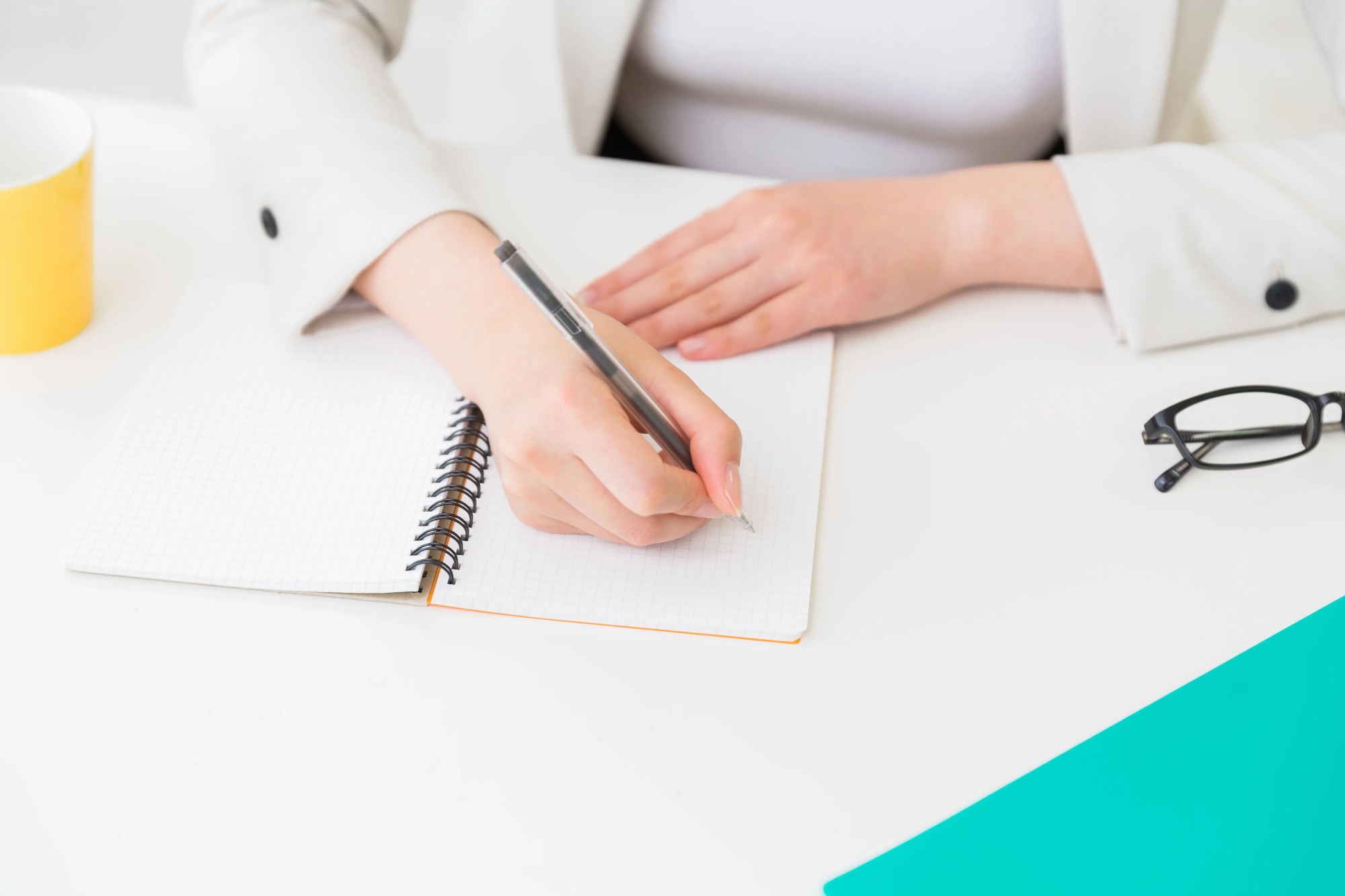 「方法」のイメージ_ノートに何かを書き込む女性の手元