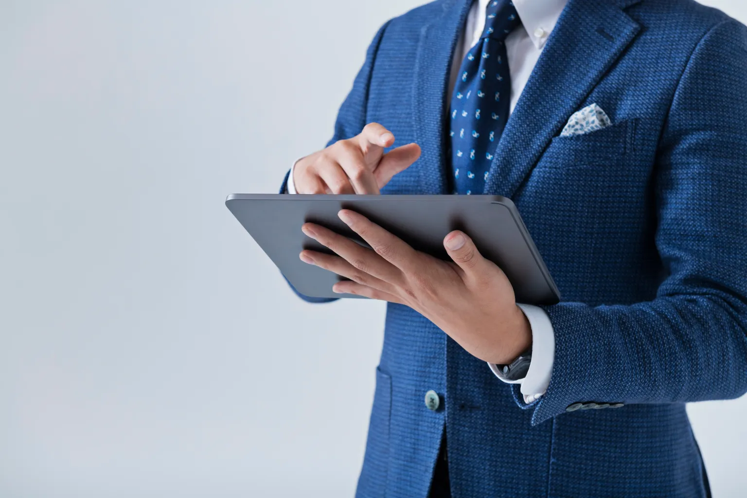 「調査」のイメージ_タブレットを操作する男性の手元
