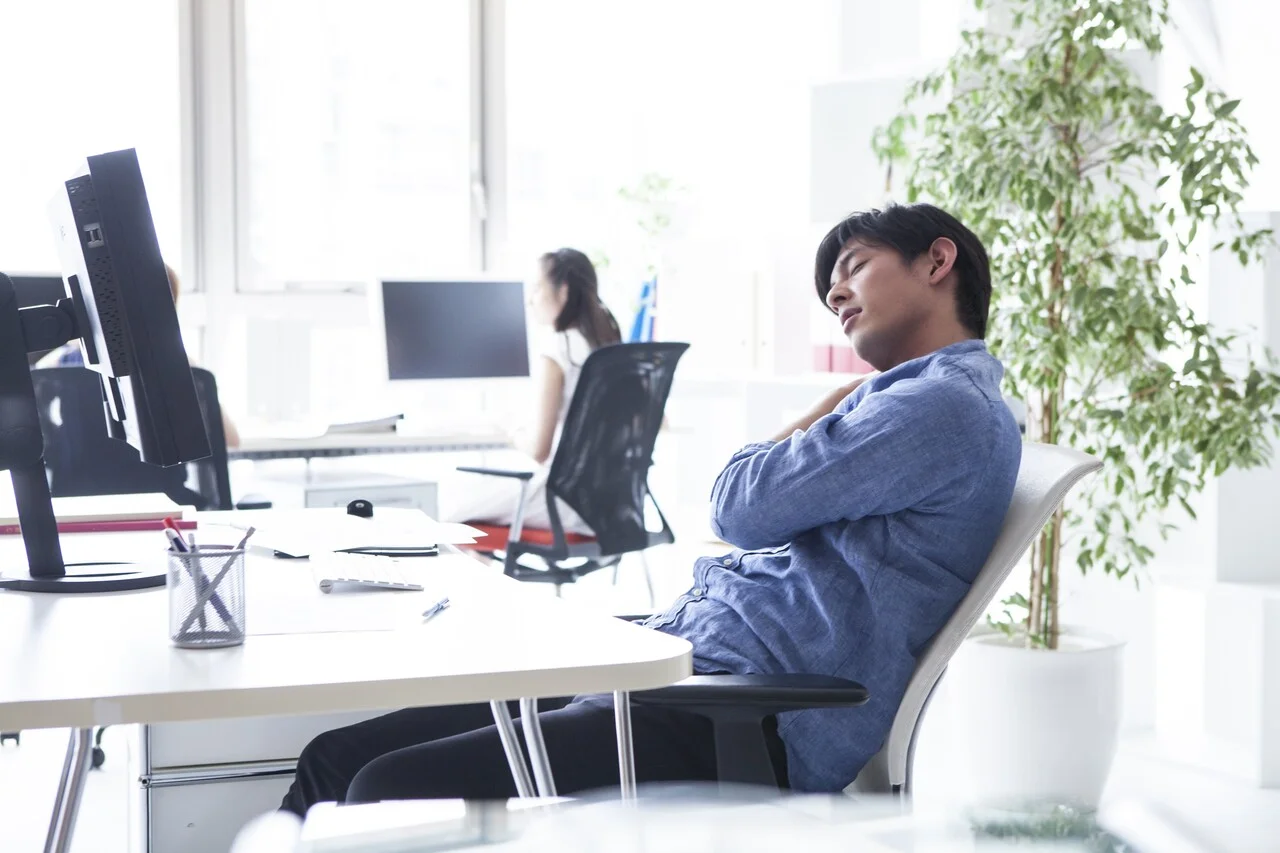 「疲労」のイメージ_デスクで辛そうに肩を揉む男性