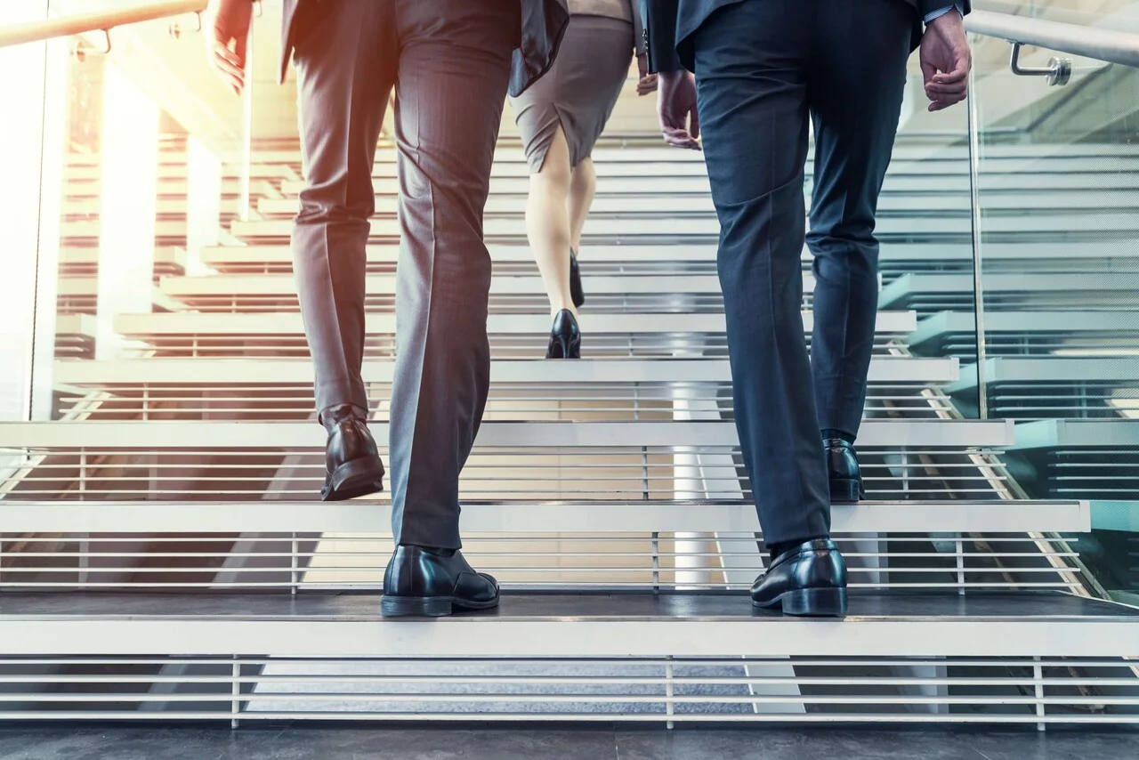 「ステップ」のイメージ_階段を登る複数名の社員の足元