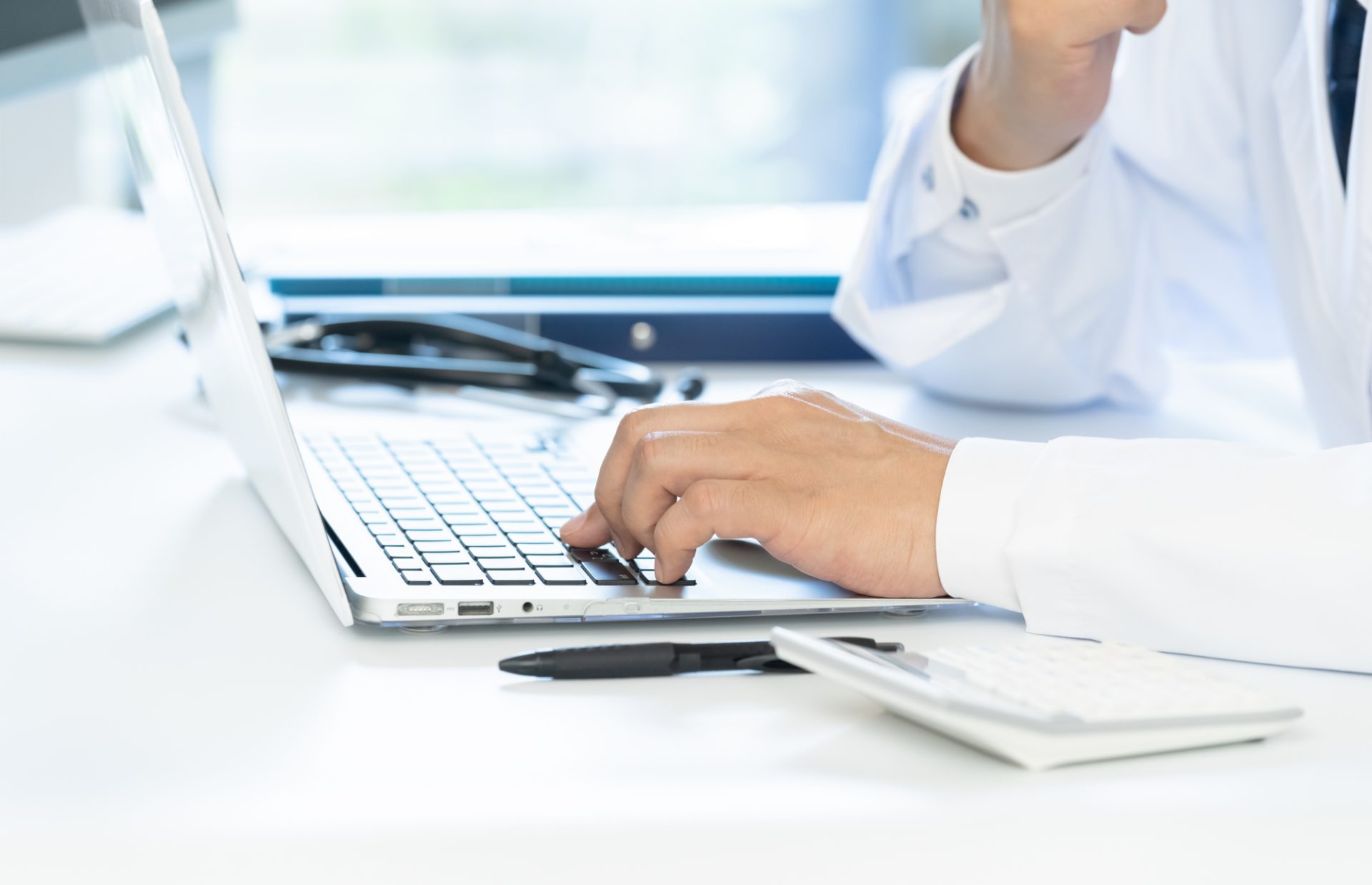 「産業医」のイメージ_パソコンを見ながら悩む産業医の手元