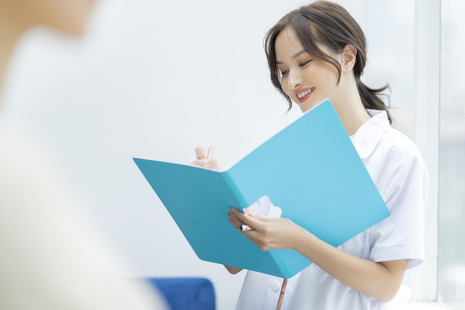 「看護師」のイメージ_笑顔で資料を見る看護師