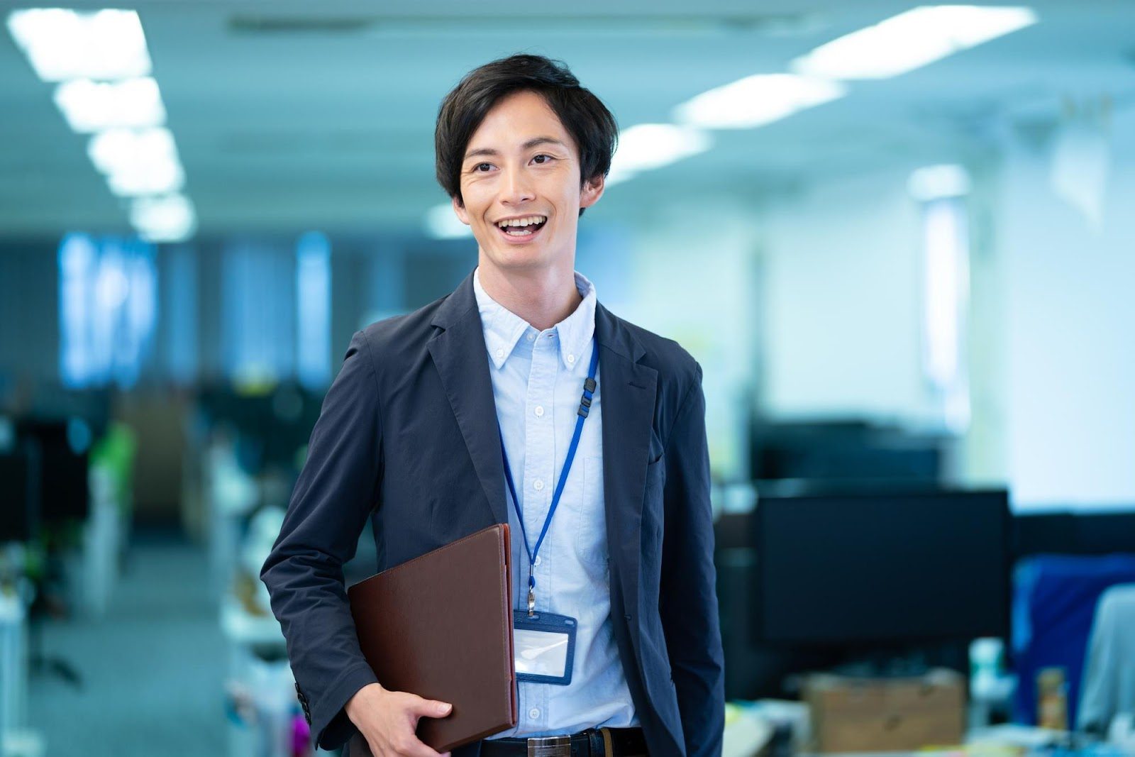 「解決策」のイメージ_笑顔を浮かべて社内を歩く男性