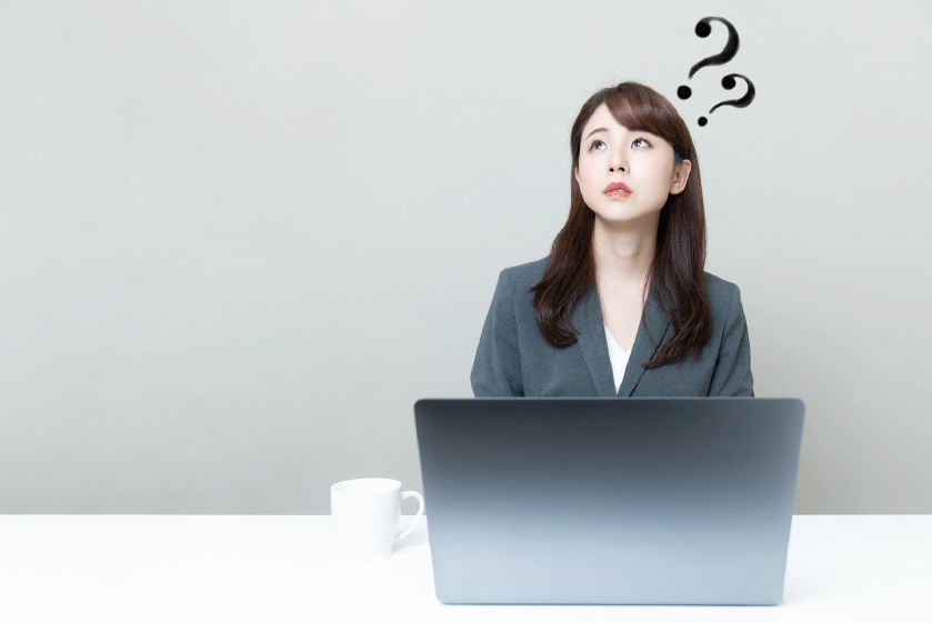 【疑問】のイメージ_女性がパソコンの前で頭にはてなを浮かべている様子