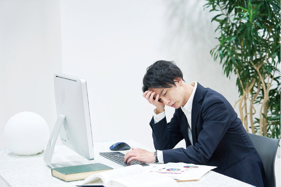【疲労】のイメージ_男性がデスクの前で疲労している様子