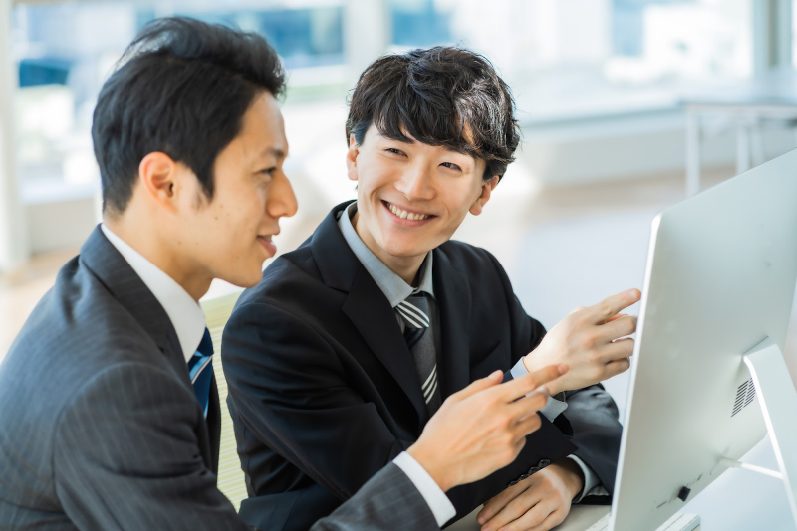 【相談】のイメージ_笑顔で話をしている新入社員と管理職